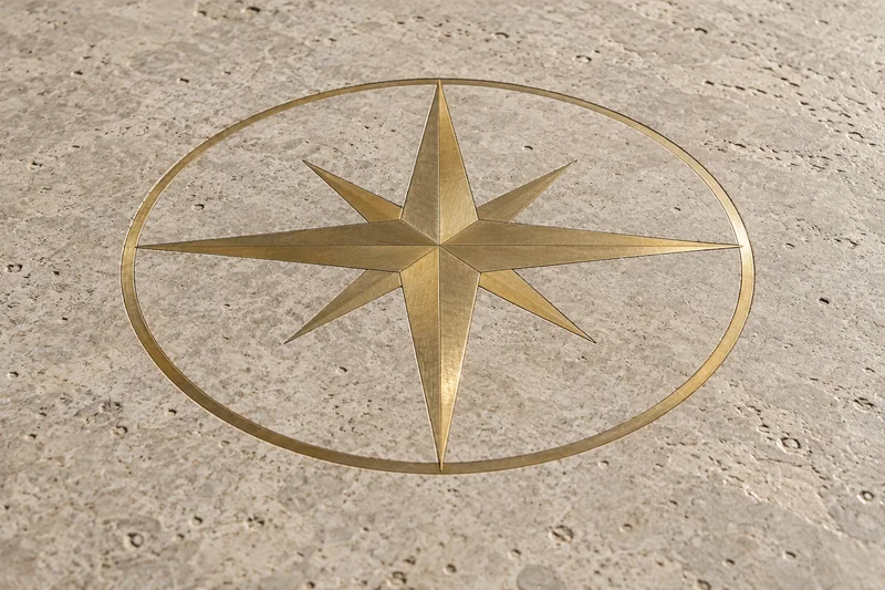 A brass compass rose inlaid flush into a pale stone floor
